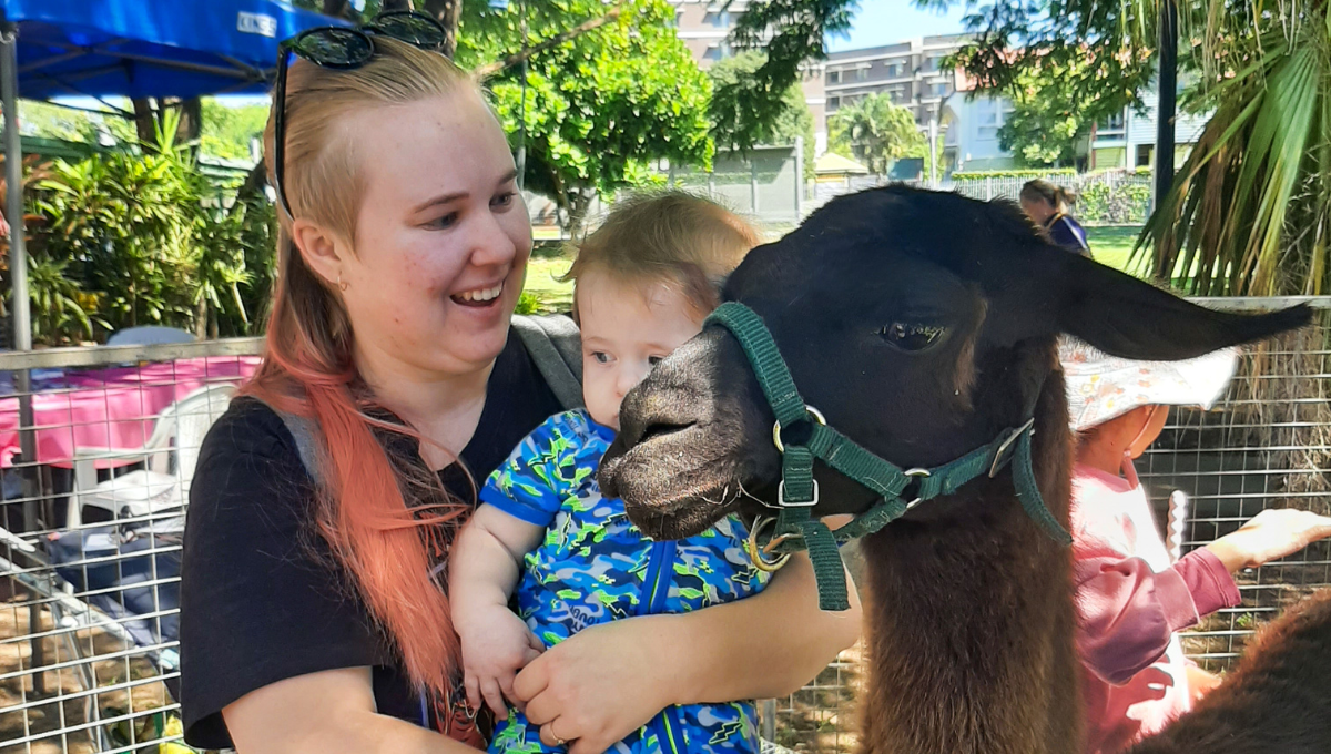 Photo of mother, baby, and animal at the Wellbeing Expo